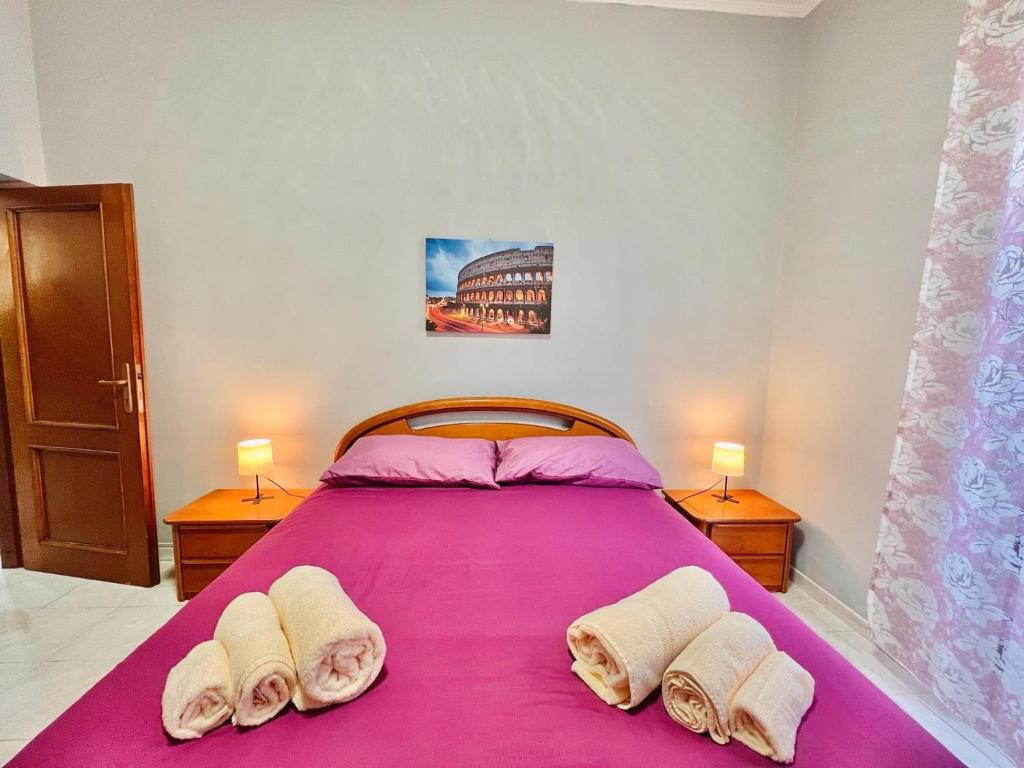 a bedroom with a large purple bed with two lamps at Begonie House in Rome