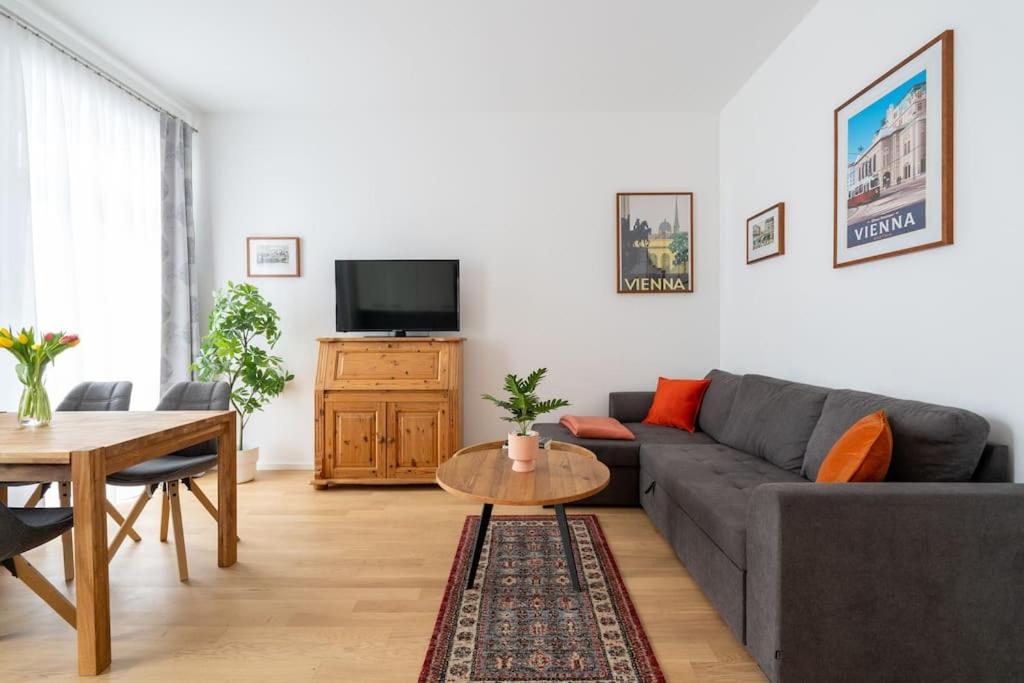 ein Wohnzimmer mit einem Sofa und einem Tisch in der Unterkunft HM • Cosy 1BR Near Westbahnhof in Wien
