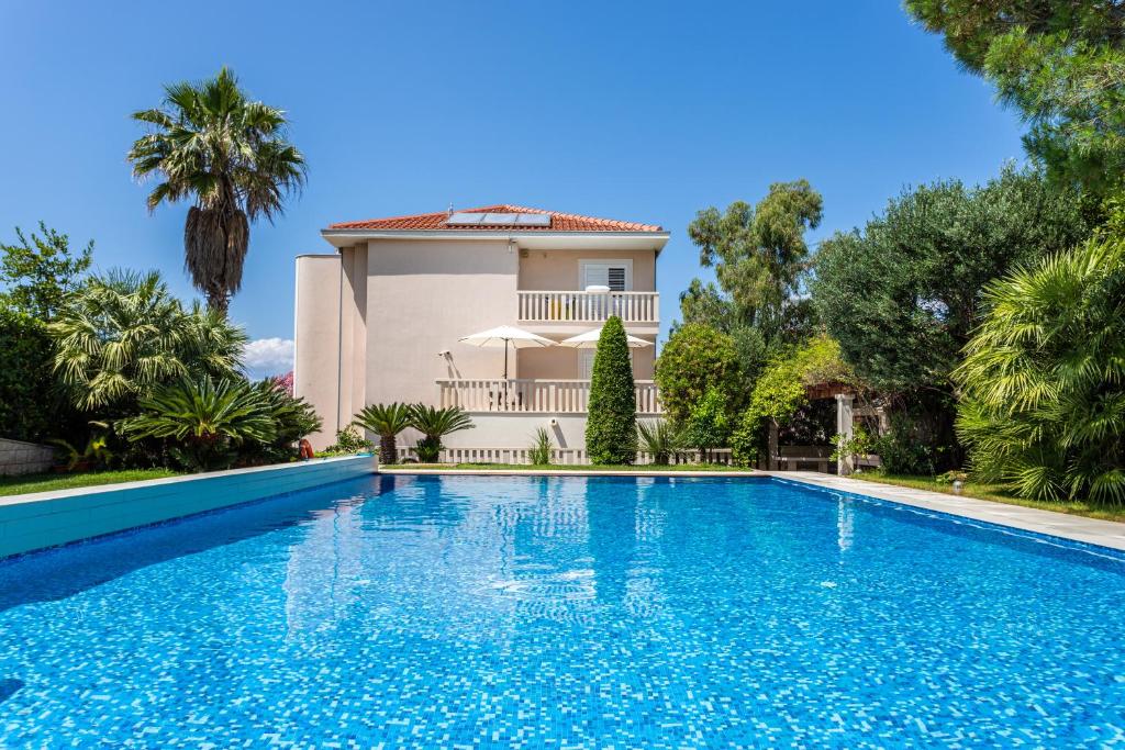 een villa met een zwembad voor een huis bij Apartments Keti in Splitska
