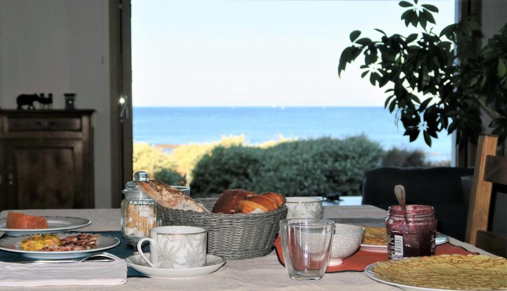 a table with a basket of bread and plates of food at Vitamin Sea in La Turballe
