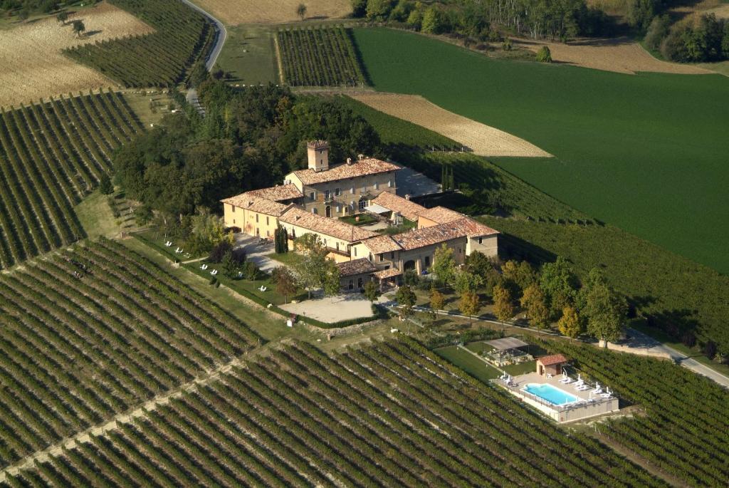 una vista aerea di una grande casa in un campo di Relais Castello di Razzano ad Alfiano Natta