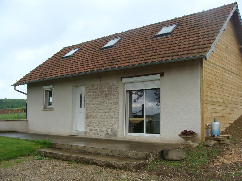 una piccola casa bianca con finestra e scale di La grange a Gasny