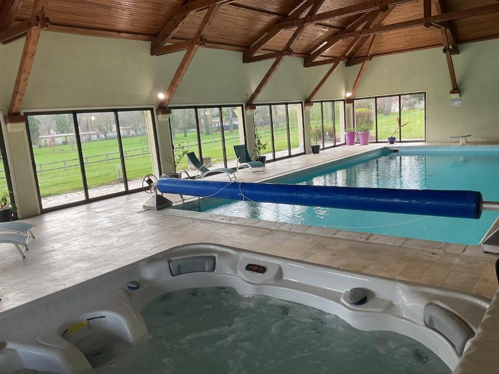a large swimming pool with a hot tub at Ma Tranquillite in Courpière