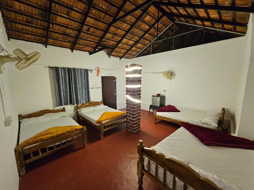 een kamer met drie bedden in een kamer bij Sakleshpur Home Stays in Sakleshpur
