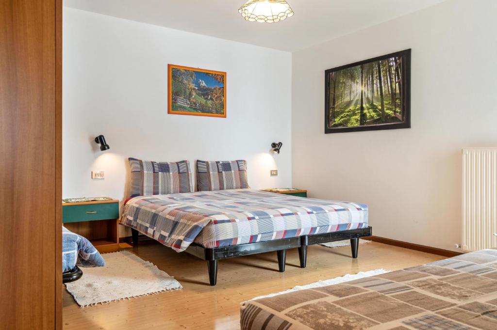 een slaapkamer met een bed, een stoel en een tafel bij Agriturismo El Cirum Pelmo in Livinallongo del Col di Lana