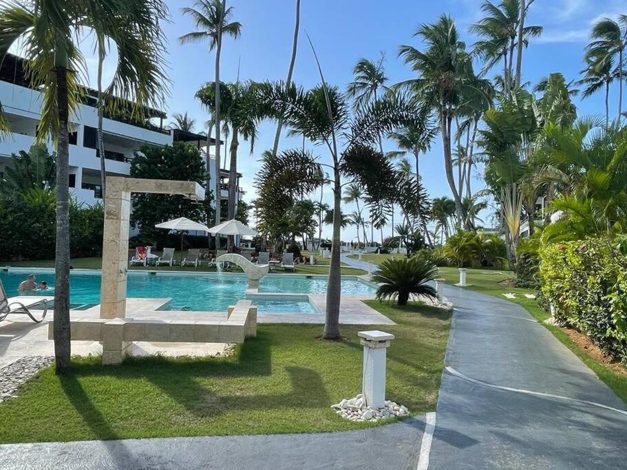 einen Pool in einem Resort mit Palmen und einem Gebäude in der Unterkunft Peaceful and lovely apartment! Front beach in Las Terrenas
