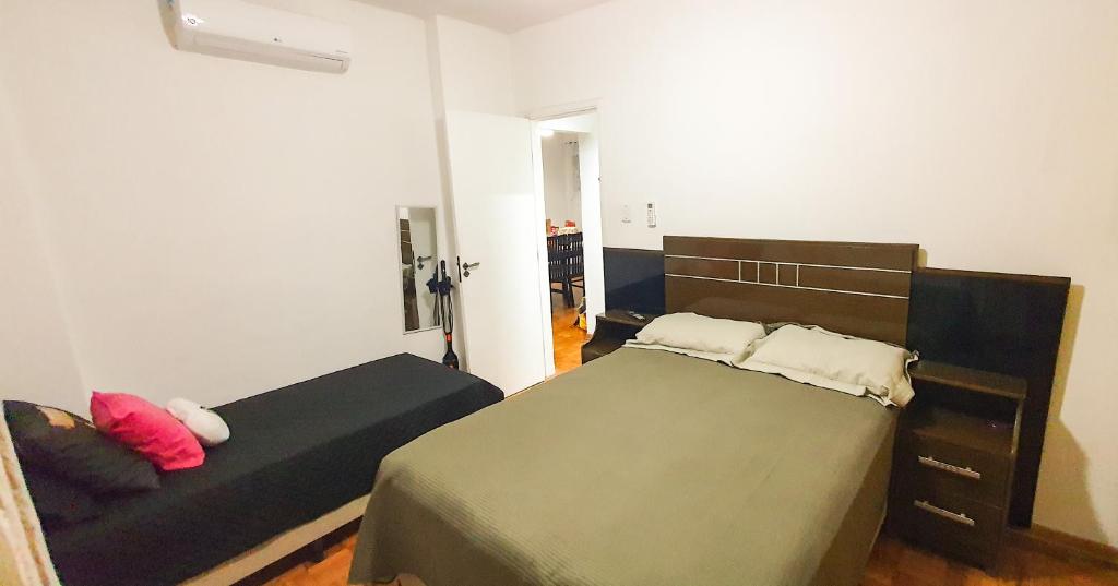 a bedroom with two beds and a couch at Santos Gonzaga - Vista mar & localização perfeita in Santos
