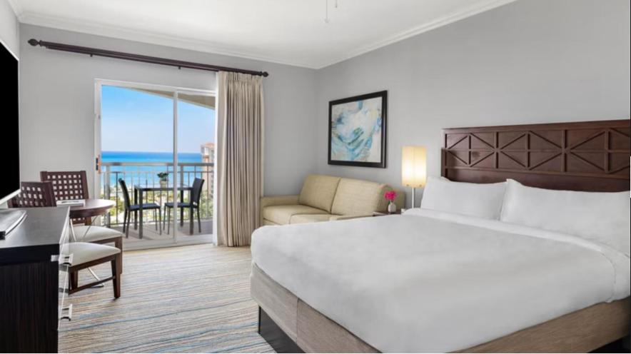 Habitación de hotel con cama grande y balcón. en Hotel Aruba, en Palm-Eagle Beach