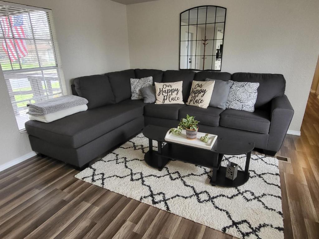 ein Wohnzimmer mit einem schwarzen Sofa und einem Tisch in der Unterkunft Green Haven Property in Austin