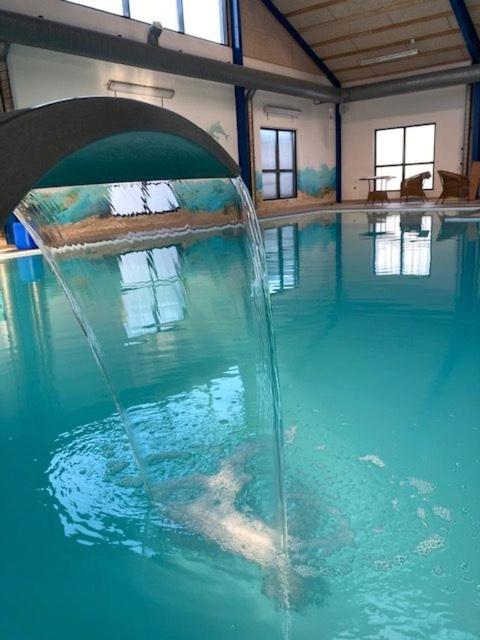 a swimming pool with a water fountain in it at Himmerland camping & Feriecenter in Års