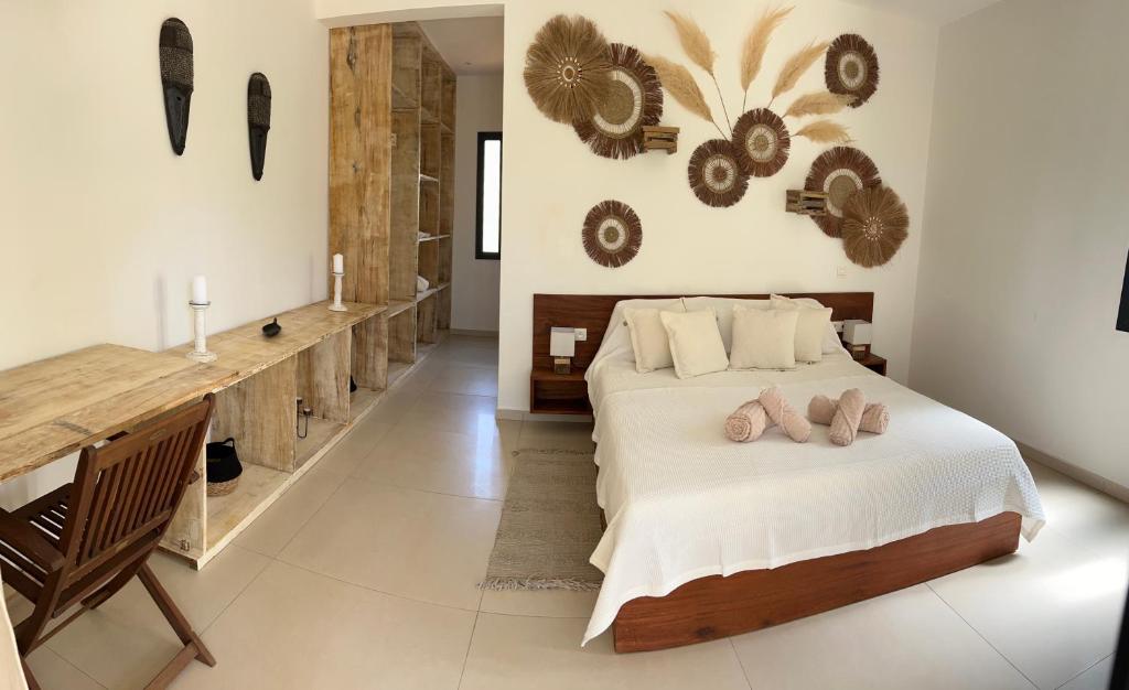 a bedroom with a bed and a desk with flip flops on it at Côté Jardin in Somone