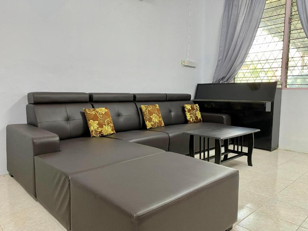 sala de estar con sofá y piano en Home Sweet Home en Kota Kinabalu