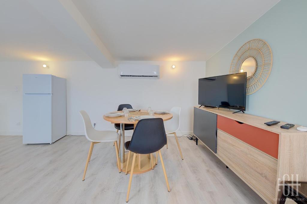 a dining room with a table and a tv at HALTE 3 &#47; GUÈS DE VEIGNE in Veigné