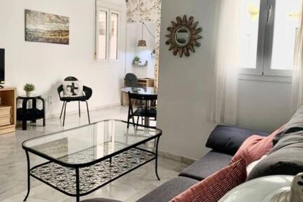 sala de estar con sofá y mesa de cristal en Cozy Comfy, en Sevilla