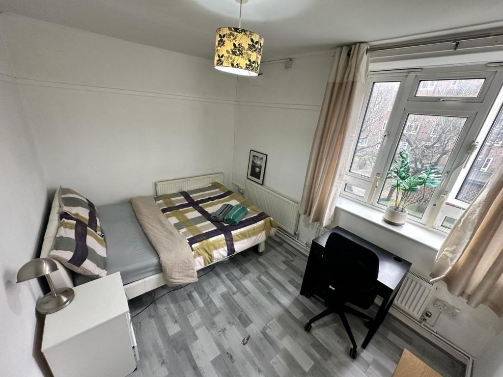 a bedroom with a bed and a desk and a chair at Aldgate East Rooms R2 in London