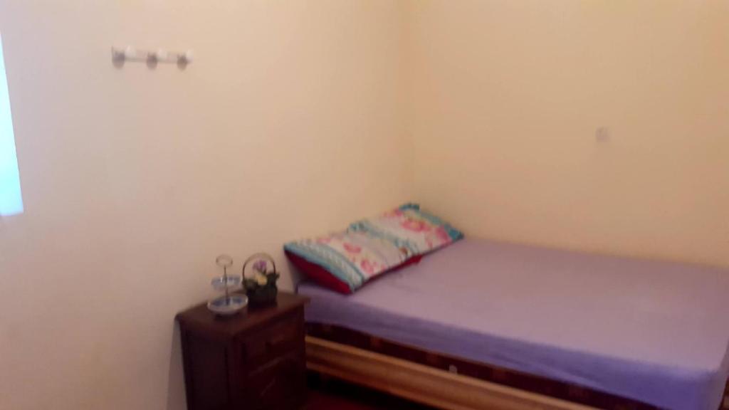 een kleine slaapkamer met een bed en een nachtkastje bij Gîte Ait Bouguemez in Azilal