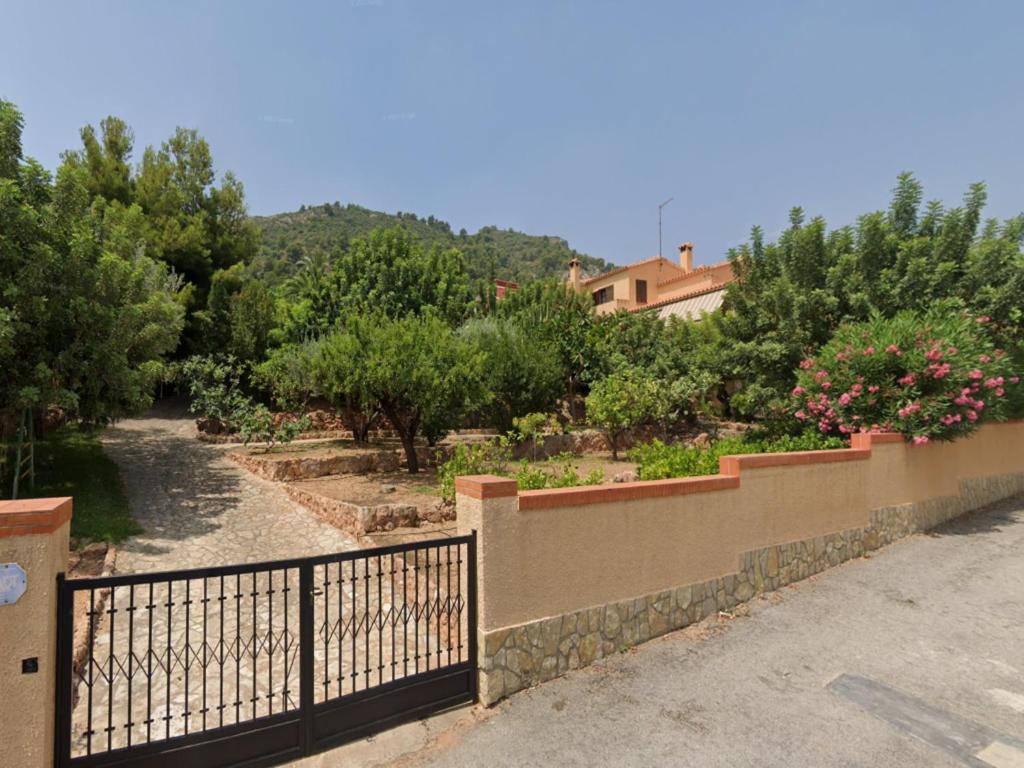 una valla frente a un jardín con flores en Villa La Torreta Ref056, en Castellón de la Plana