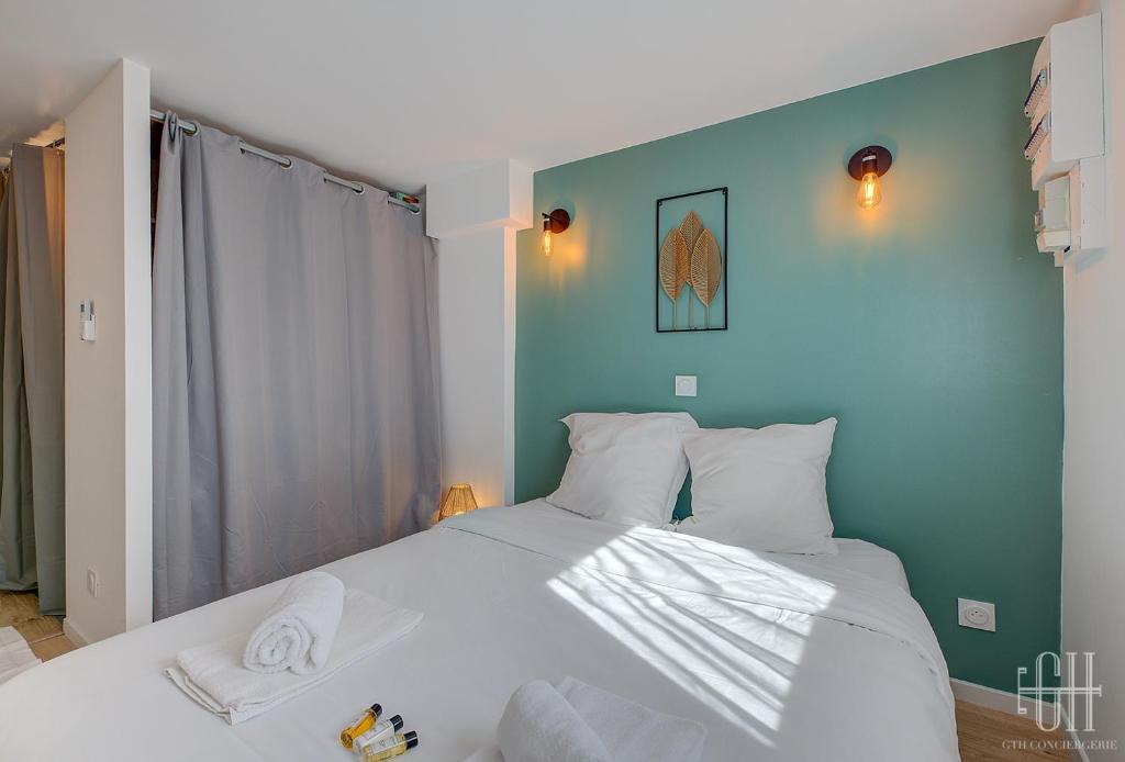 ein Schlafzimmer mit einem großen weißen Bett mit blauen Wänden in der Unterkunft La Halte 2 in Veigné