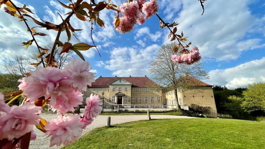 ein Gebäude mit rosa Blumen davor in der Unterkunft Skjoldenæsholm Slot in Jystrup