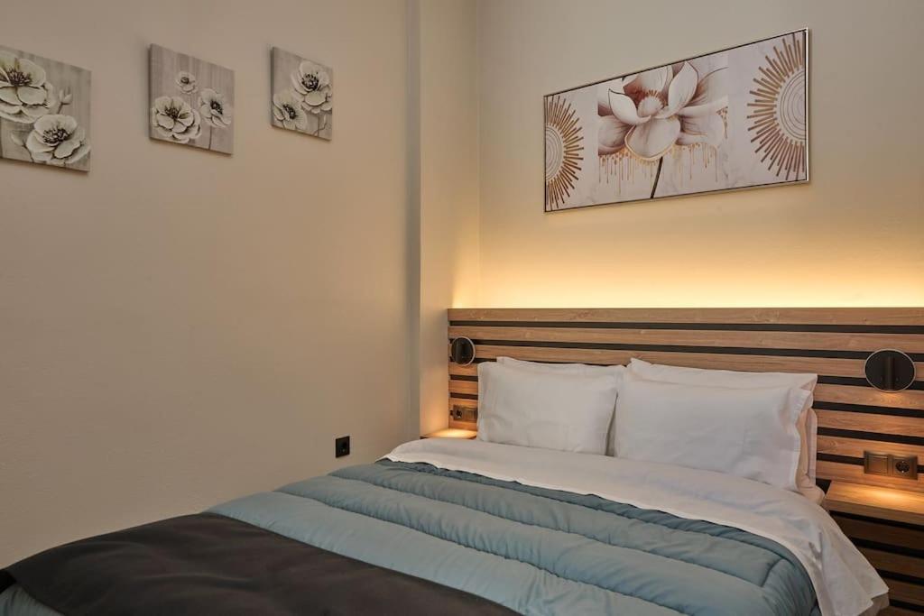 2024 superior modern studio! في ميتيليني: سرير في غرفة نوم مع صورتين على الحائط