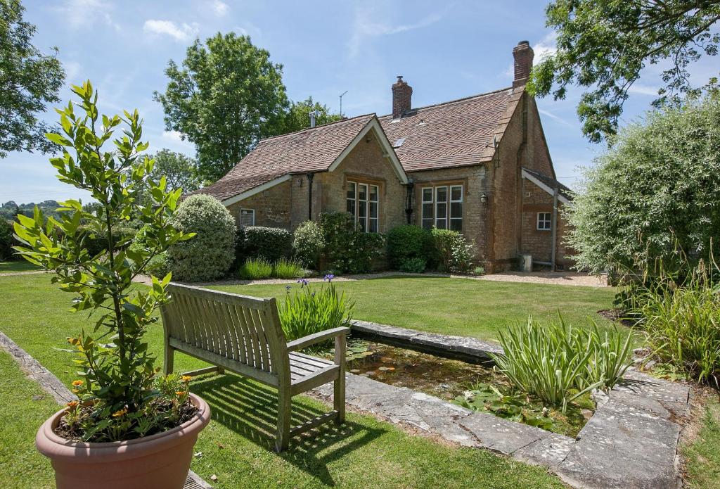 a bench sitting in the yard of a house at The Old School in South Perrott