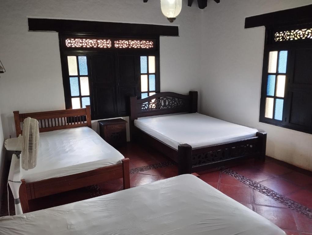 a room with two beds and two windows at Finca el hato in Palmira