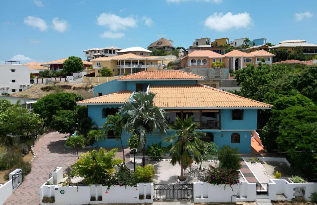 a blue house with a tile roof at Casa Leonore II in Willemstad