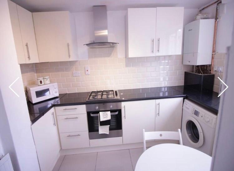 a kitchen with white cabinets and a washing machine at Double Room near Canary Wharf 32 in London
