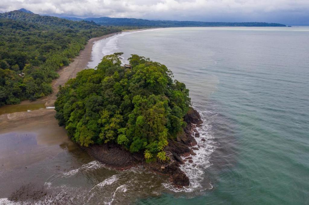 an island in the ocean with trees on it at Morro Terco Hotel Boutique in Nuquí