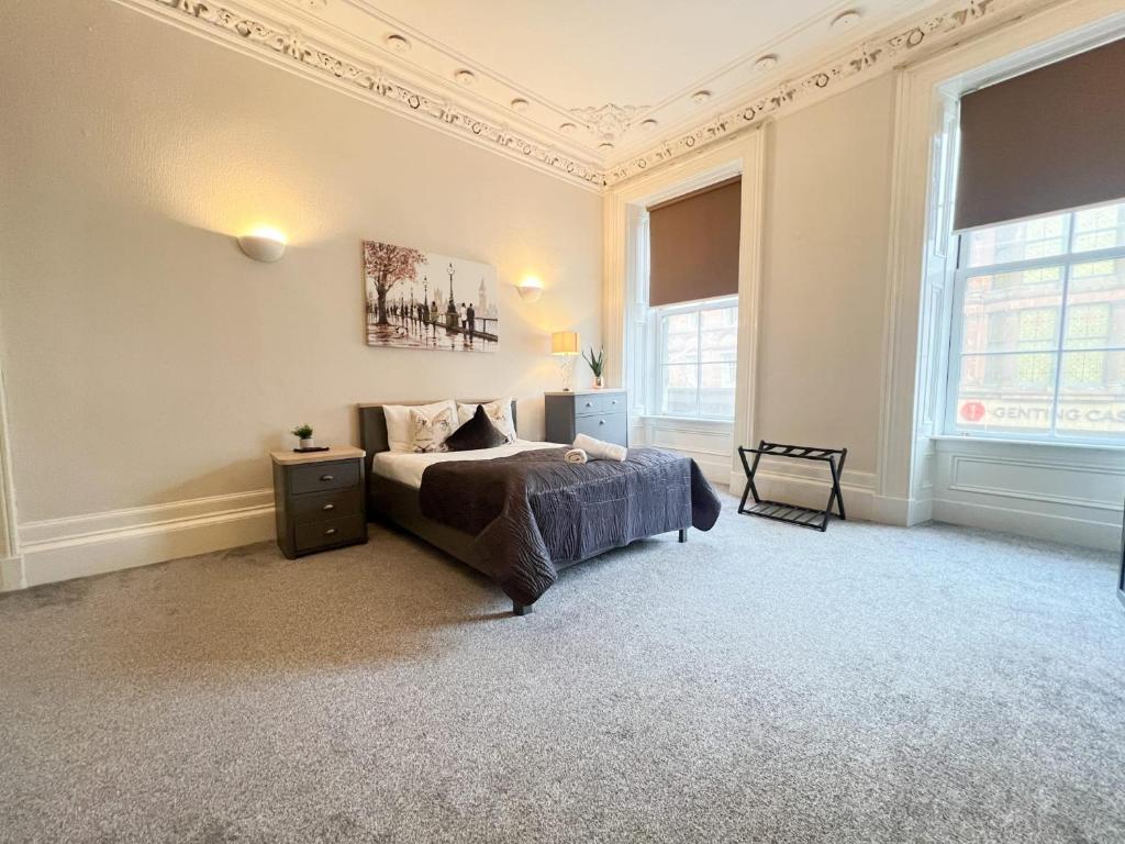 グラスゴーにあるCity Centre 5 Bedroom Flat on Sauchiehall Streetのベッドルーム1室(ベッド1台、窓2つ付)