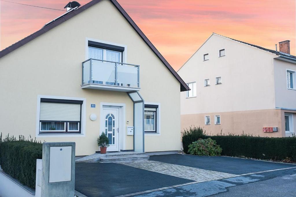 a white house with a balcony and a driveway at Ferienwohnung Rebekka in Riedlingsdorf