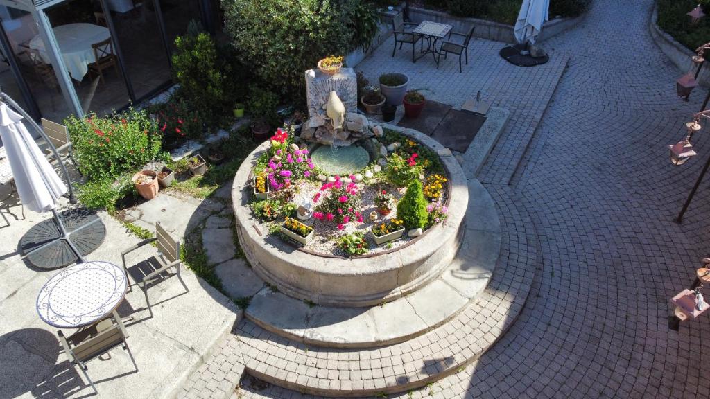 an overhead view of a fountain with flowers in it at Hotel Carmel in Les Vans