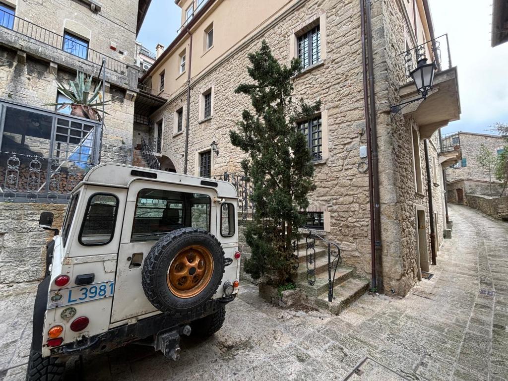 - une jeep blanche garée dans une rue à côté d'un bâtiment dans l'établissement Borgoloto Suite 17, à Saint-Marin