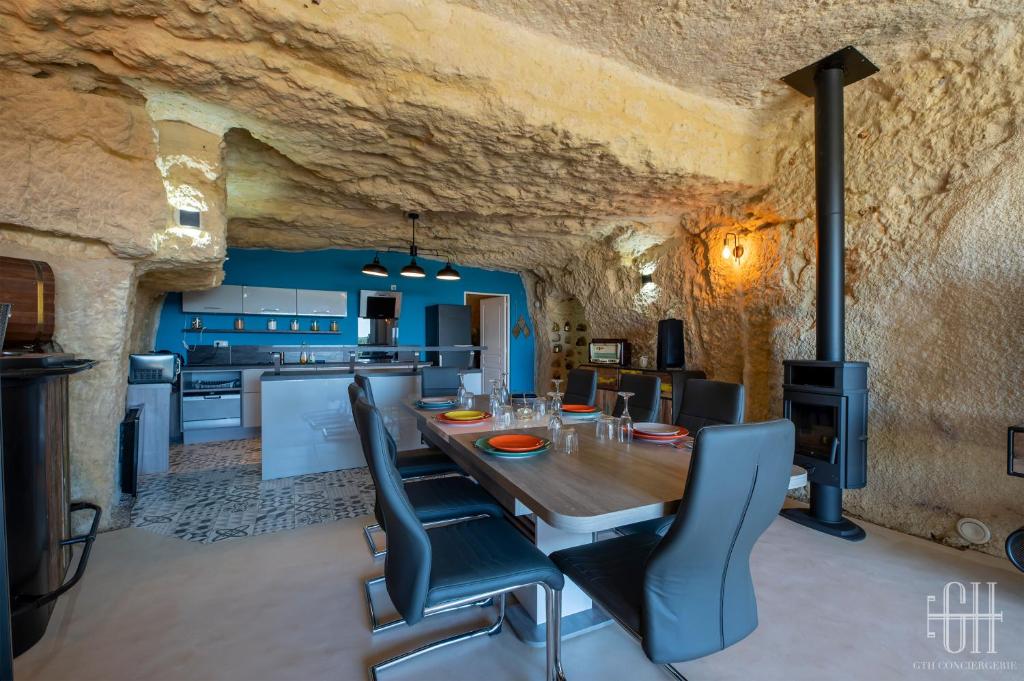 eine Küche und ein Esszimmer mit Tisch und Stühlen in der Unterkunft La Troglo - Maison typique de notre région in Vouvray