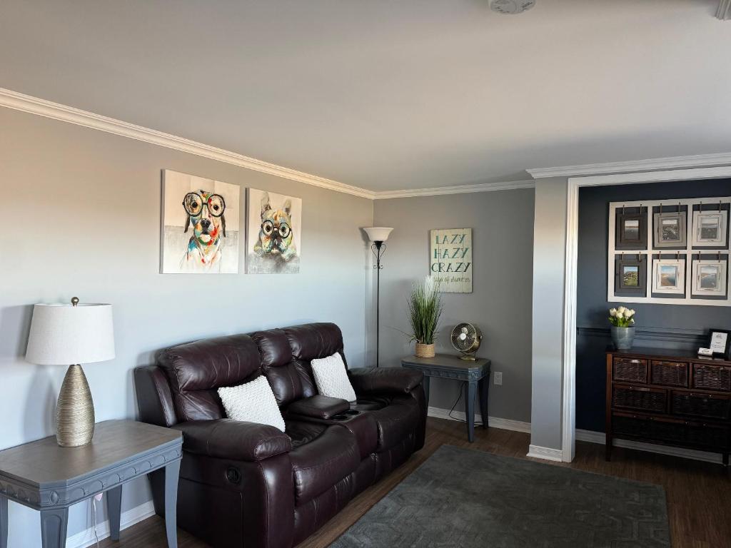 a living room with a leather couch and a table at Lazy Days Vacation Rental in Picton