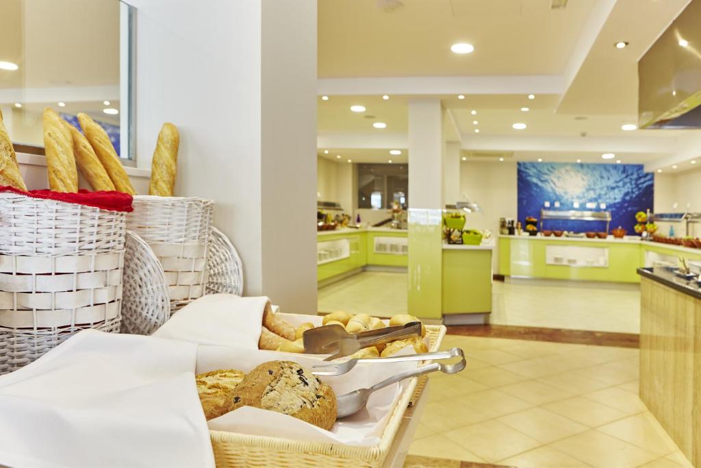 a bakery with baskets of bread on a table at Universal Hotel Marqués in Colònia de Sant Jordi