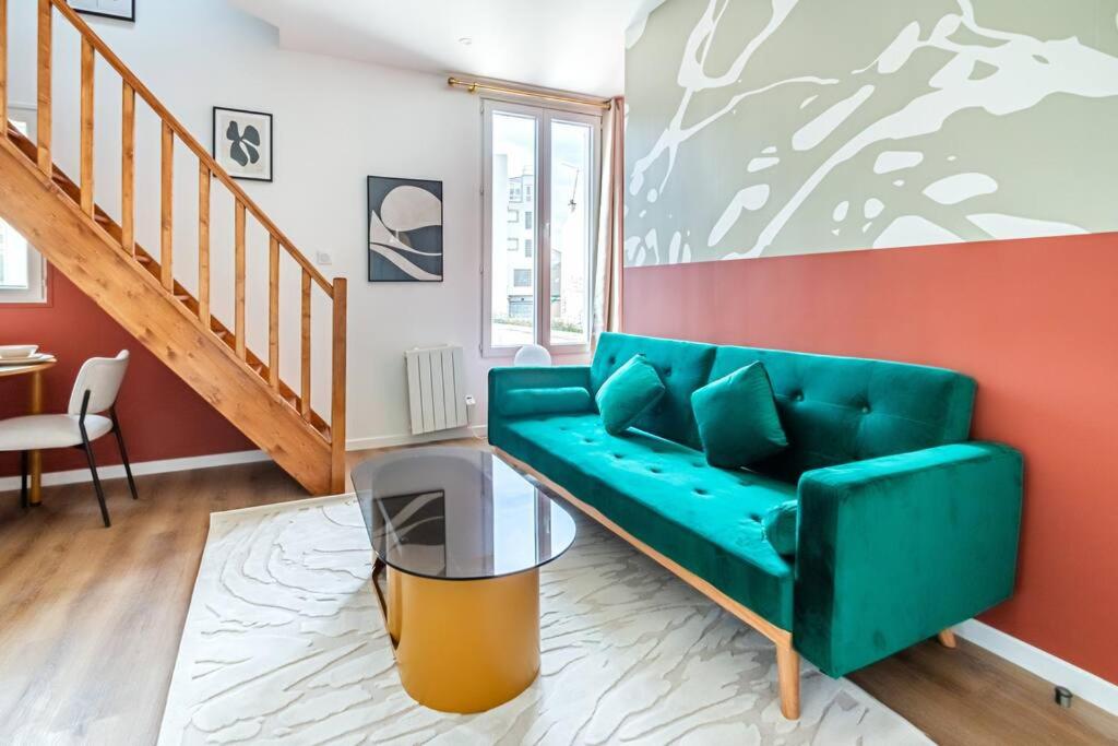 - un salon avec un canapé vert et un escalier dans l'établissement Appartement coloré à 5 minutes de Paris, à Bagnolet