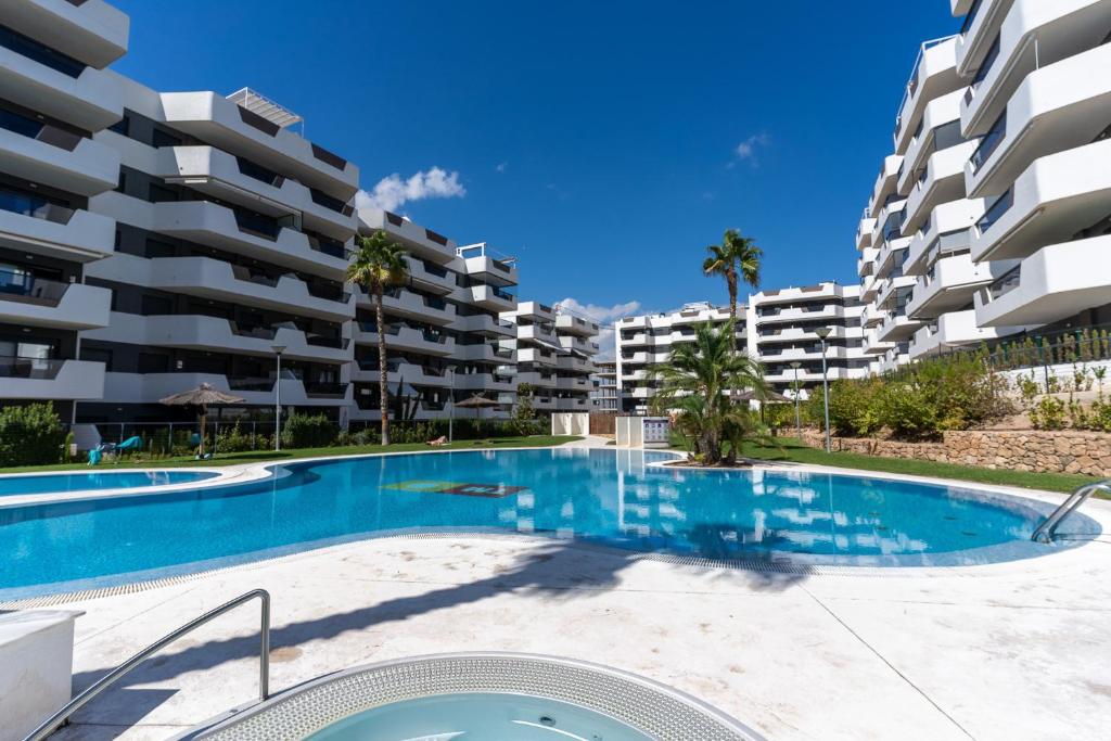 a swimming pool in front of a large apartment building at Arenales Bahia Penthouse in Arenales del Sol