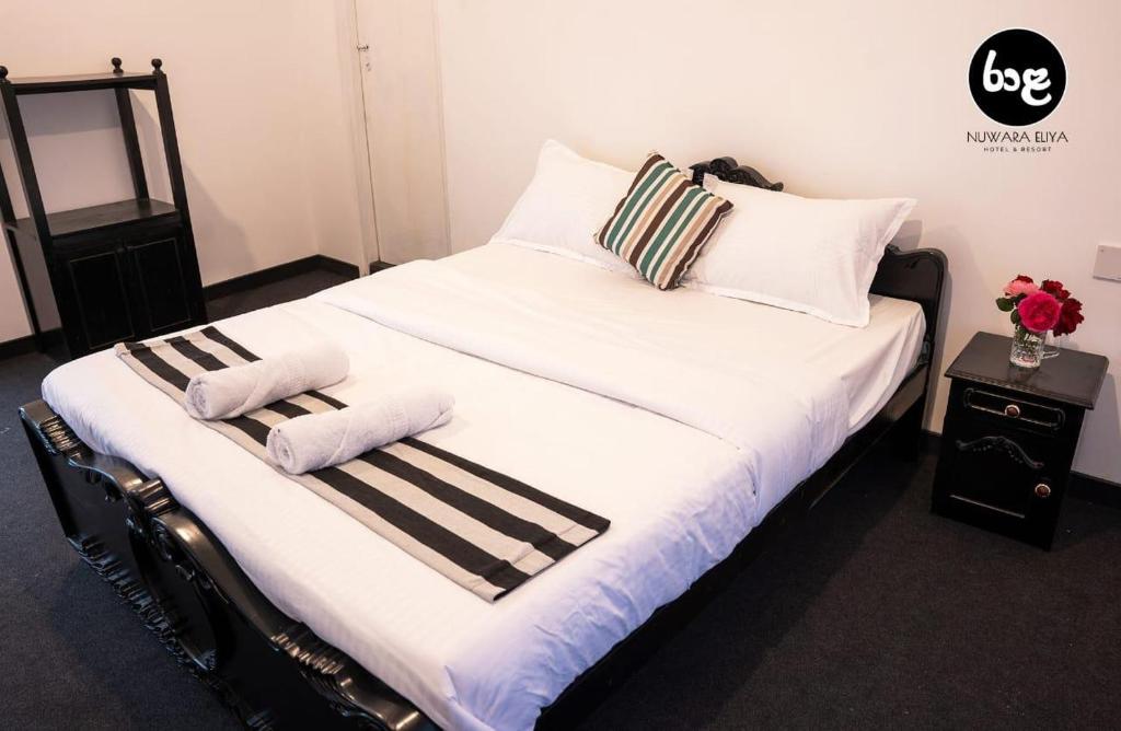 ein großes weißes Bett mit zwei Handtüchern darauf in der Unterkunft Raala Nuwara Eliya Hotel & Resort in Nuwara Eliya