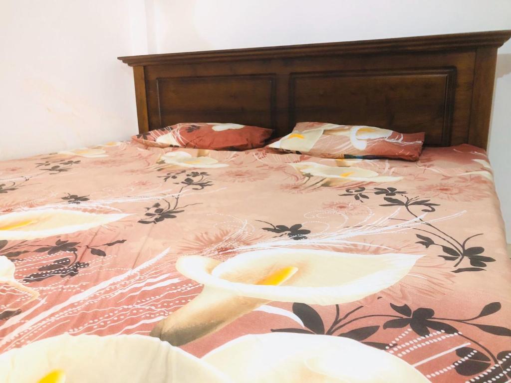 a bed with a pink bedspread with flowers on it at SK Villa in Galle