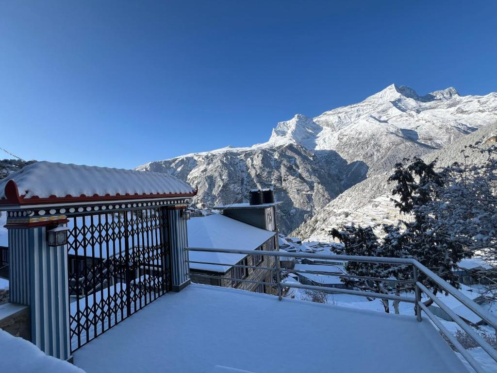 einen schneebedeckten Balkon mit Bergen im Hintergrund in der Unterkunft Namche Terrace in Namche