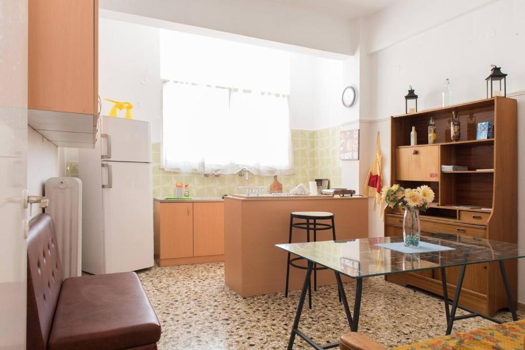 uma cozinha com uma mesa e um frigorífico em Hellas Palace ROOMS LOFT em Sparti