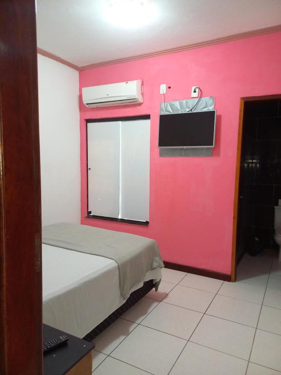 um quarto com uma cama e uma parede vermelha em HOTEL AL MARE ATLANTICO em Aracaju