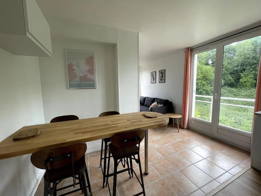 Una sala de estar con una mesa y sillas de madera. en Charmant logement avec parking privé., en Veules-les-Roses