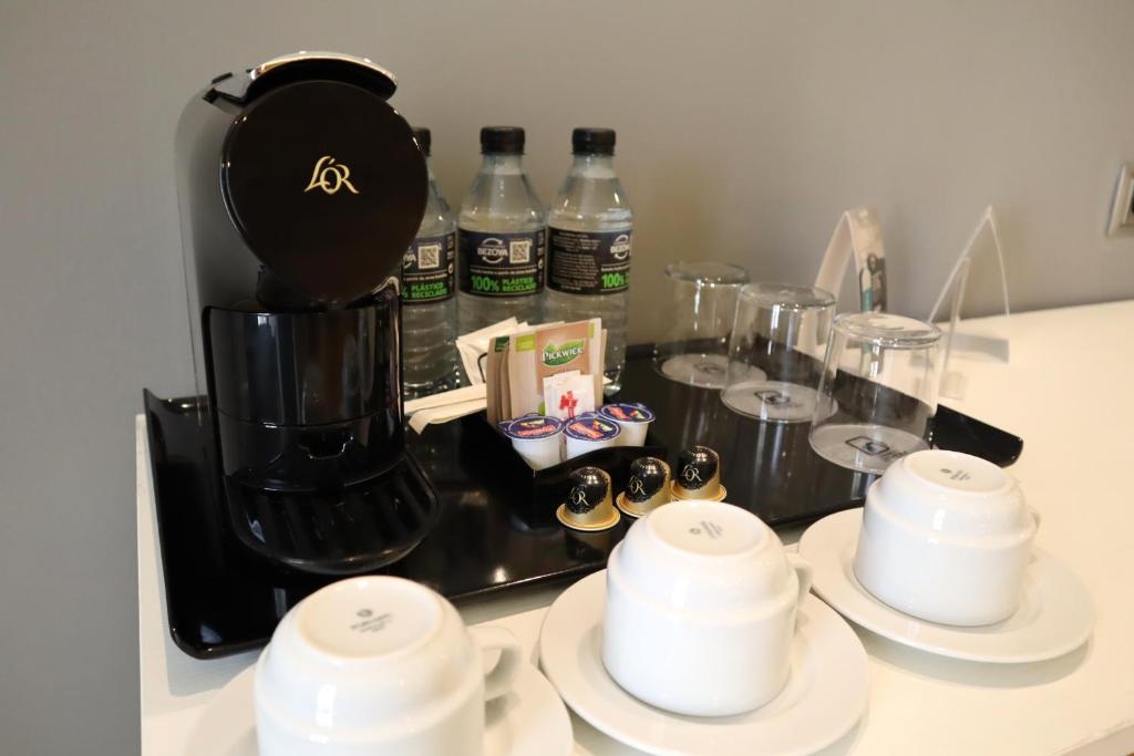 Hotel Monte Puertatierra في كاديز: كاونتر المطبخ مع آلة صنع القهوة وبعض الأكواب