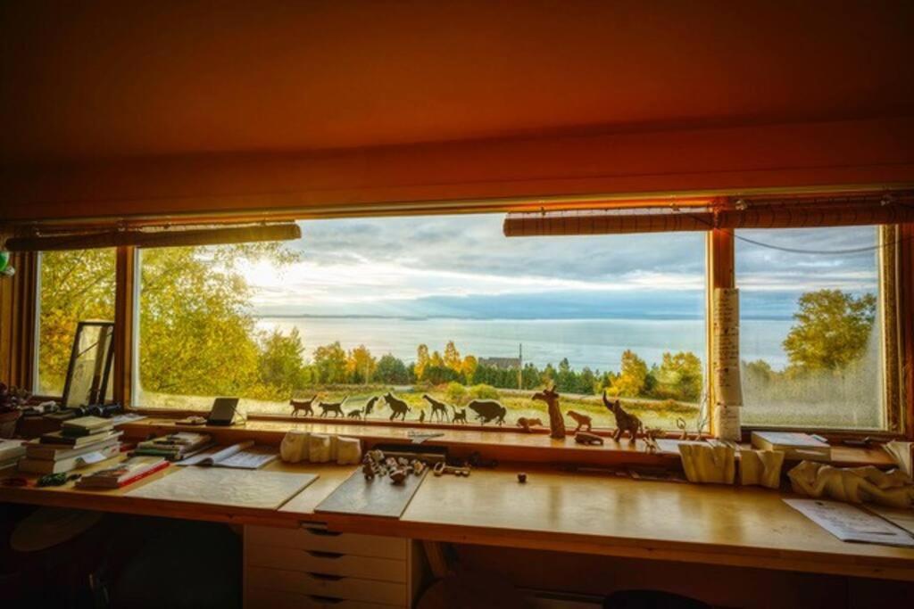 a desk with a window with a view of a field at Le Remous in La Malbaie