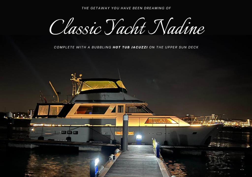 a boat docked at a dock at night at Classic Yacht Nadine in Poole Harbour, Dorset, with a Hot Tub Jacuzzi in Poole
