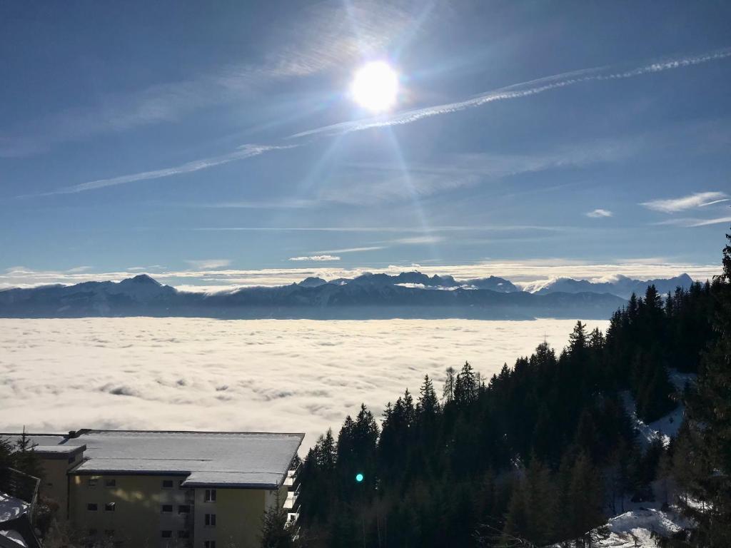 a view of the sun over the clouds and mountains at Apartment sunny mountains Gerlitzen in Deutschberg