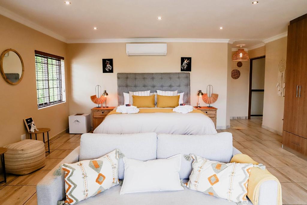 1 dormitorio con 1 cama grande y 1 sofá en Sandy Creek Safaris en Kransberg