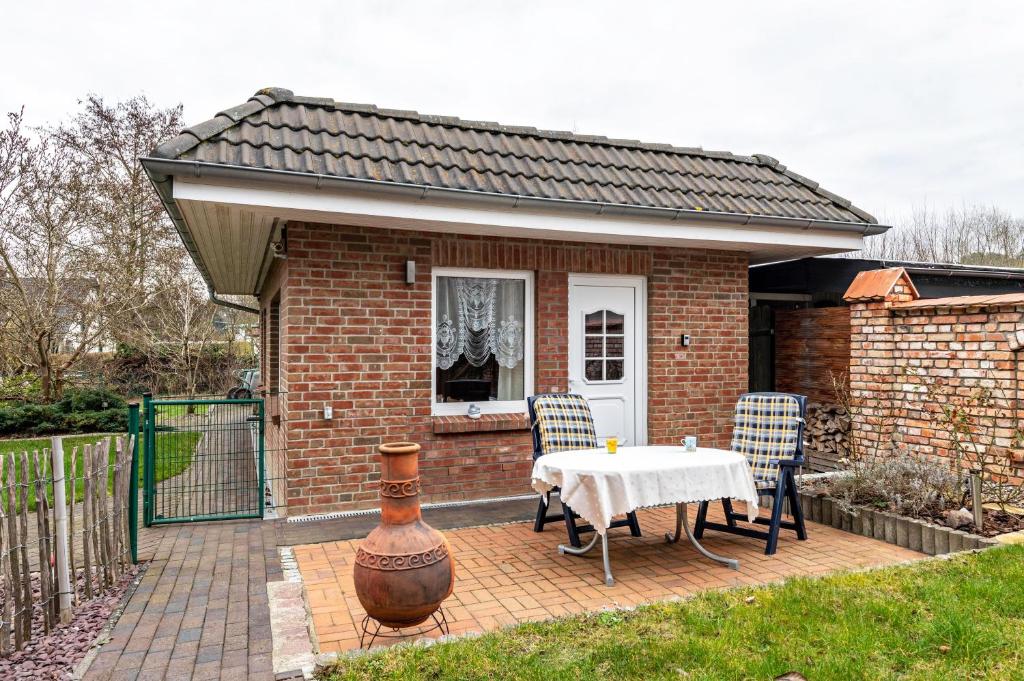 een stenen huis met een tafel en stoelen op een patio bij Ferienhaus Krakow am See in Krakow am See